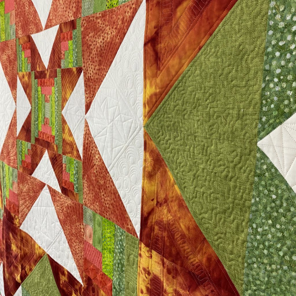 Supernova original quilt in orange, green and white, custom quilting